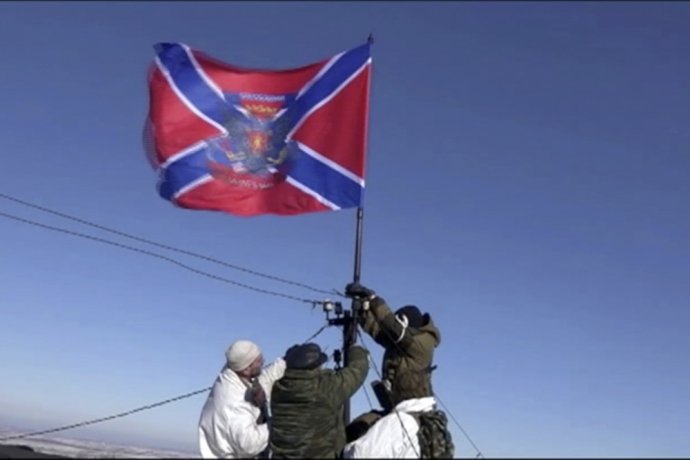 Proruskí separatisti vztyčujú svoju vlajku na výškovej budove v Debaľceve. Foto - AP/Channel 1