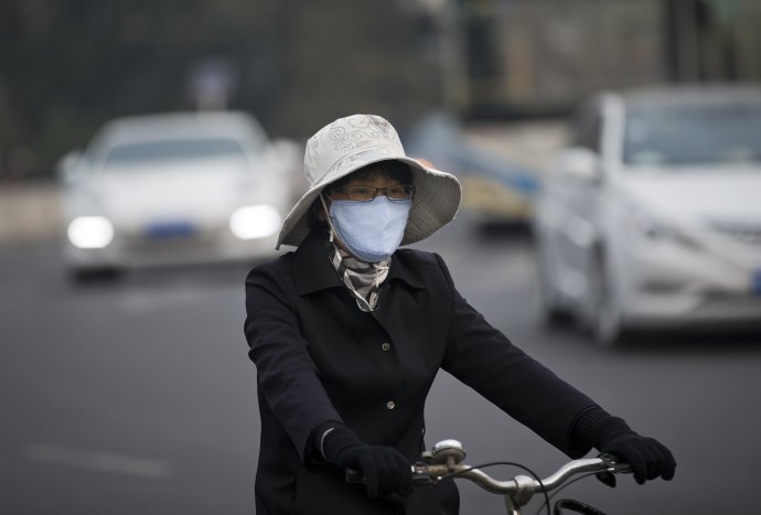 Čoraz viac domácich nosí v čínskych mestách rúška. Foto – TASR/AP