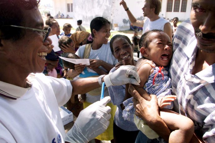 Pracovník UNICEF očkuje dieťa proti osýpkam vo Východnom Timore. Ilustračné foto - TASR