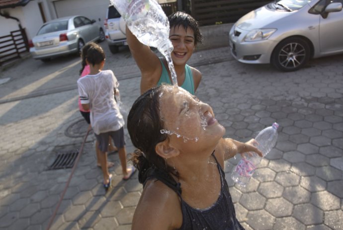 Kosovské deti sa olievajú vodou. Štyridsaťstupňové horúčavy prišli aj na Balkán. FOTO - AP