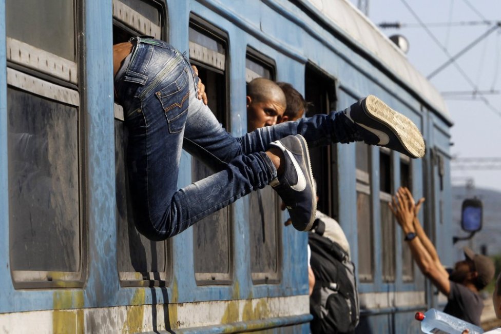 Utečenci sa snažia dostať do vlaku cez okno na juhu Macedónska v Gevgeliji.
