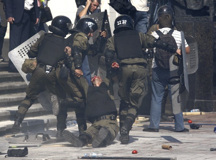 Členovia zásahovej jednotky odnášajú svojho kolegu spred budovy parlamentu v Kyjeve. Foto - TASR/AP