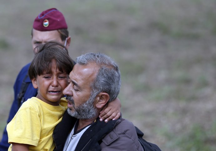Tohoto muža s dieťaťom maďarská kameramanka potkla. Foto - AP