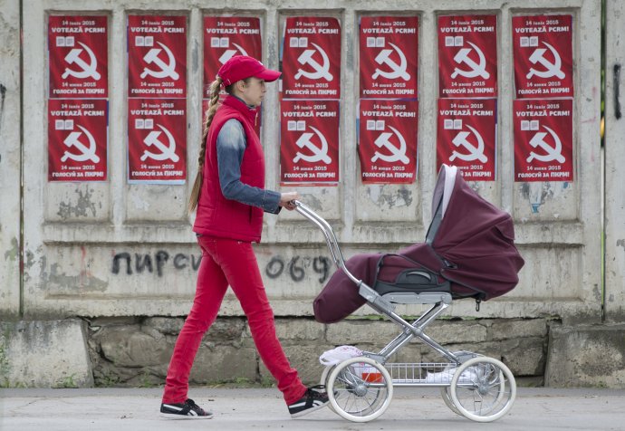 Žena tlačí kočík okolo plagátov moldavskej komunistickej strany v Kišiňove. Foto – TASR/AP