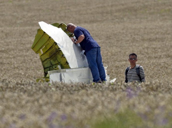 Malajzijskí leteckí vyšetrovatelia skúmajú trosky lietadla Boeing 777 na mieste dopadu pri obci Hrabove na východe Ukrajiny. FOTO - TASR/AP