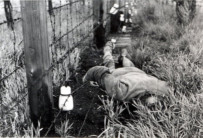 Na reprodukcii fotografie z roku 1984 je telo muža, ktorý zahynul pri plote s vysokým napätím pri pokuse o prekročenie československo-rakúskej hranice na úseku Bratislava-Devín. Foto – TASR/Ústav pamäti národa