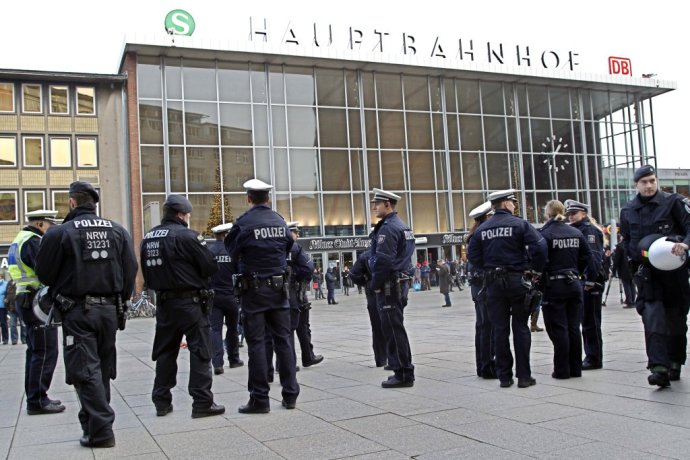 Policajti hliadkujú pred hlavnou stanicou v Kolíne. Foto - TASR/AP