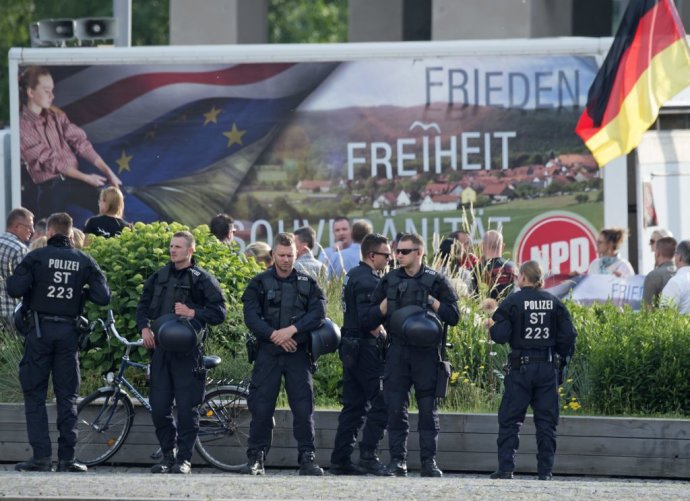 Policajti dohliadajú na priebeh demonštrácie pravicovo extrémistickej strany NPD. Foto: AP/tasr
