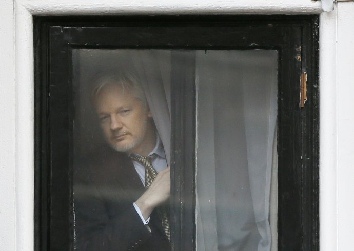 Zakladateľ WikiLeaks Julian Assange sa pozerá z okna ekvádorského veľvyslanectva v Londýne. Foto – TASR/AP