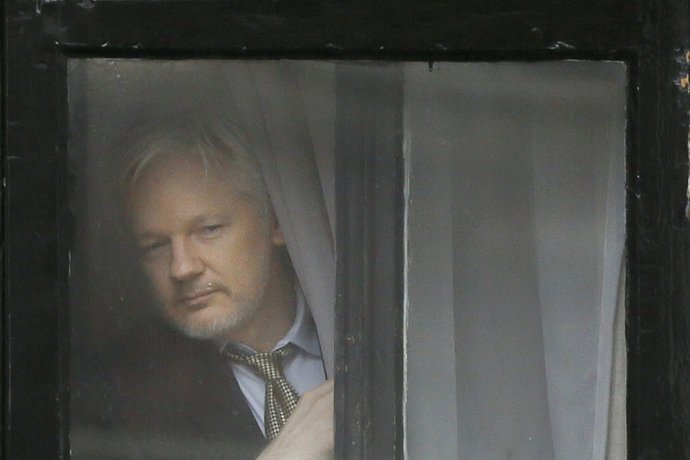 Zakladateľ WikiLeaks Julian Assange sa pozerá z okna ekvádorského veľvyslanectva v Londýne. Foto - ap