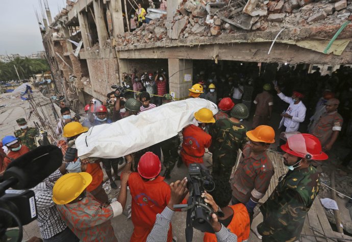 Záchranári vynášajú telo jednej z obetí zrútenia textilnej továrne v Bangladéši. Foto – TASR/AP