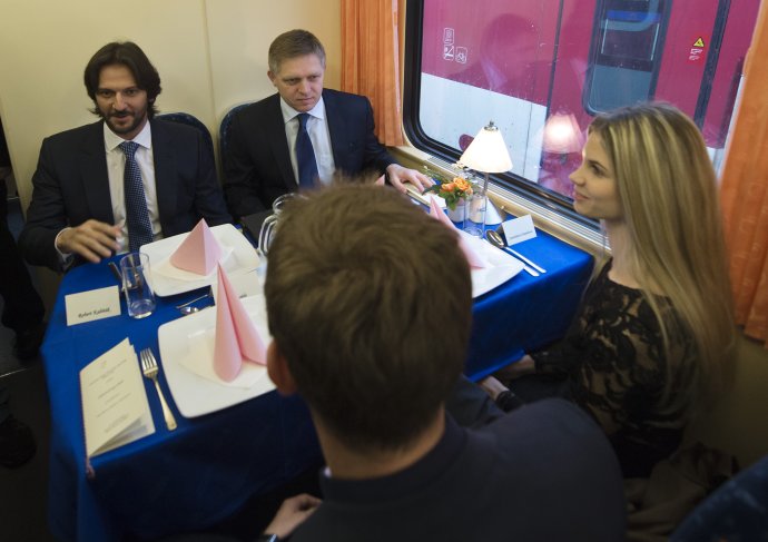 Robert Fico a Robert Kaliňák obedujú vo vlaku so študentmi 17. 11. 2014 krátko po tom, ako ohlásili spustenie takzvaných vlakov zadarmo. Foto – TASR