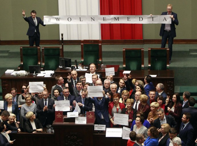 Opoziční poslanci spievajú poľskú hymnu pri rečníckom pulte v parlamente. Foto – TASR/AP