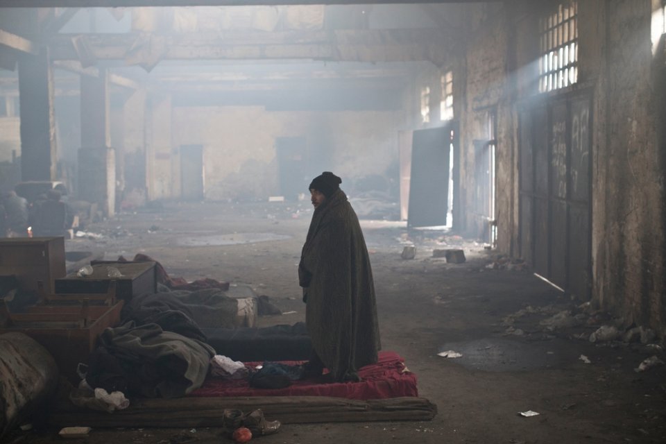 Muž stojí v starom železničnom sklade, kde teraz žijú migranti. Foto - Marko Drobnjakovic/Lekári bez hraníc