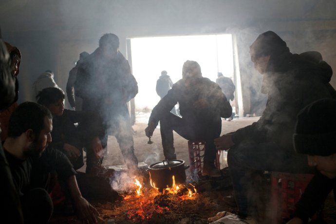 Utečenci si varia na ohni v železničnom sklade v Belehrade. Foto – Marko Drobnjakovic/Lekári bez hraníc