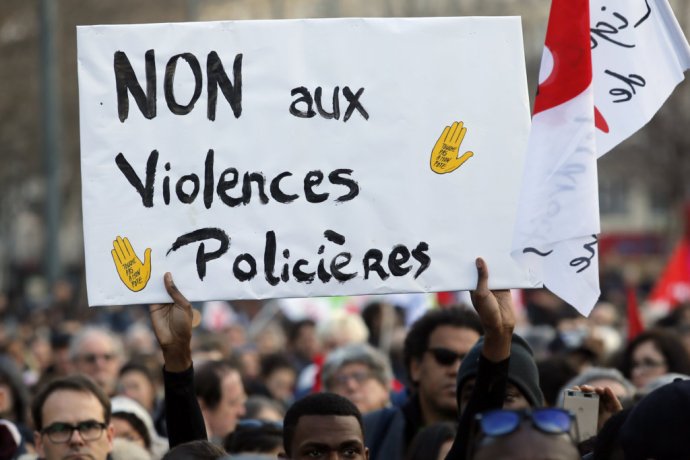 Transparent s nápisom „Nie policajným násilnostiam“ drží jeden z protestujúcich na parížskom predmestí. Foto – TASR/AP