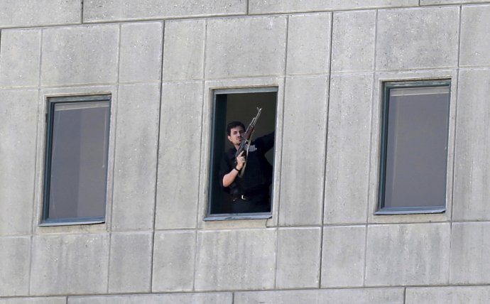 Ozbrojený muž sa pozerá z okna parlamentnej budovy v Teheráne. Foto - ap