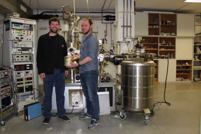 Tobias Meier (vľavo) a Remy Pawlak (obaja z univerzity v Bazileji) pred skenovacím tunelovacím mikroskopom vo svojom laboratóriu držia trofej z prvých pretekov nanoáut. Foto – Martina R. Hestericová