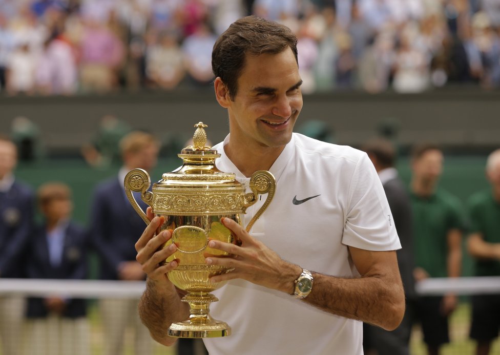 Švajčiarsky tenista Roger Federer s trofejou pre víťaza Wimbledonu. Iba on vyhral turnaj osemkrát. Foto – AP