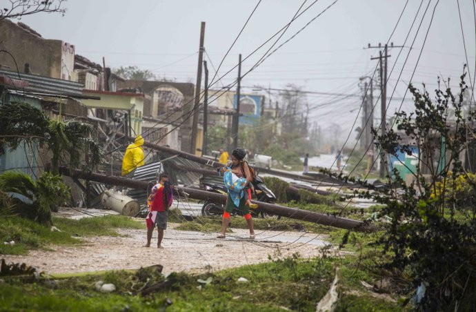 Kubánci prechádzajú po ulici po vyčíňaní hurikánu Irma. Foto – AP