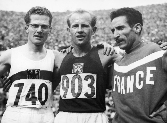 Na archívnej snímke z 24. júla 1952 zľava Nemec Herbert Schade, Emil Zátopek z Československa a Francúz Alain Mimoun pózujú v cieli po pretekoch na 5 000 metrov na letnej olympiáde na Olympijskom štadióne v Helsinkách. Zlatú olympijskú medailu získal Emil Zátopek, ktorý do cieľa dobehol v novom olympijskom rekorde 14:06:6 minút. Foto – TASR/AP