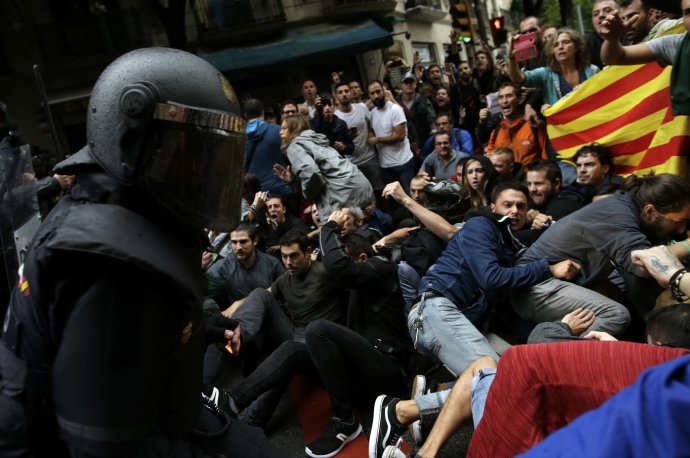 Polícia zasahuje proti ľuďom počas referenda o nezávislosti Katalánska. Foto – AP