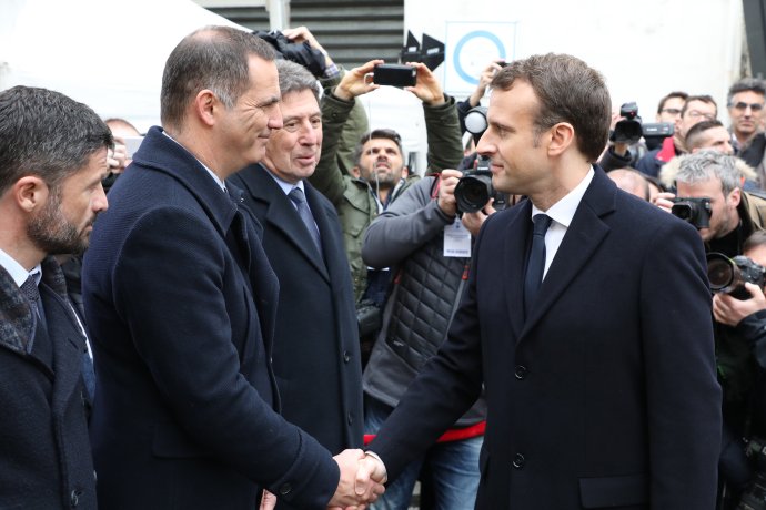 Francúzsky prezident Emmanuel Macron podáva ruku lídrovi nacionalistov na Korzike Gillesovi Simeonimu. Foto – TASR/AP