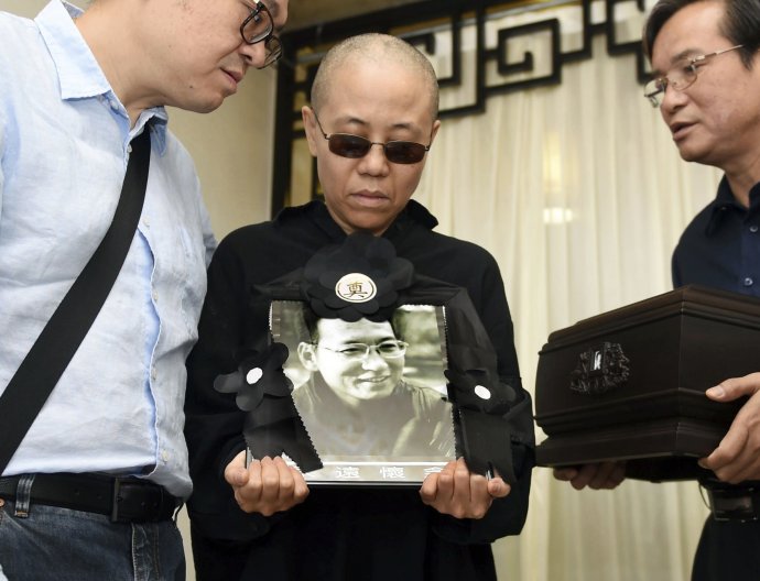 Liou Sia s fotkou svojho zosnulého manžela. Foto - TASR/AP