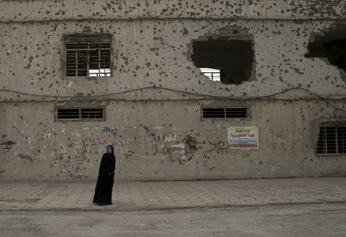 Žena v zničenom irackom Mosule v máji 2018 čaká v blízkosti volebnej miestnosti. Foto - AP