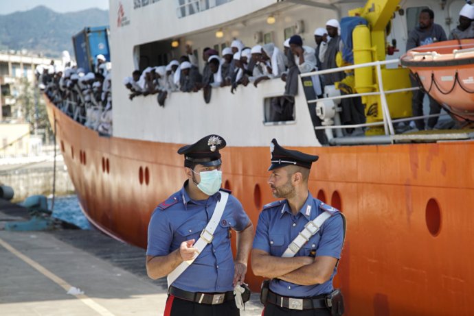 Talianski policajti stoja pred námorným plavidlom Aquarius s africkými migrantmi na palube po ich transporte v talianskom prístave Messina na Sicílii. Foto – TASR/AP