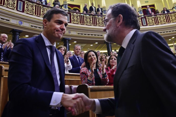 Odvolaný španielsky premiér Mariano Rajoy (vpravo) si podáva ruku so svojím nástupcom Pedrom Sánchezom. Foto – TASR/AP