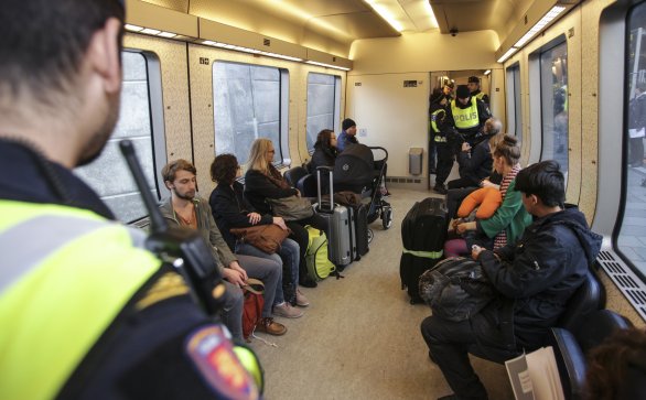 Švédski policajti kontrolujú migrantov vo vlaku z Kodane na stanici vo švédskom Malmö. Ilustračné foto – TASR/AP