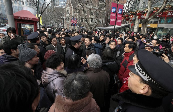 Príslušníci čínskej polície vyzývajú ľudí, aby sa rozišli, počas plánovaného protestu v Šanghaji 20. februára 2011. Foto – TASR/AP