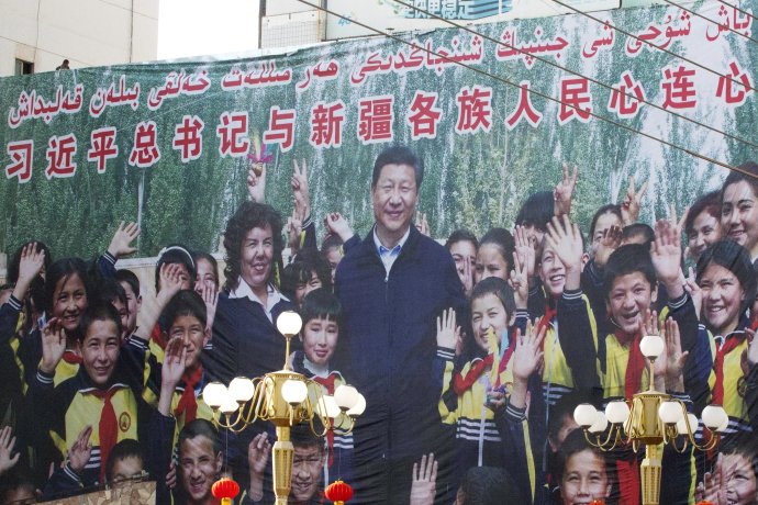 Propagandistický bilbord, na ktorom je čínsky prezident s deťmi zo Sin-ťiangu. Foto - AP
