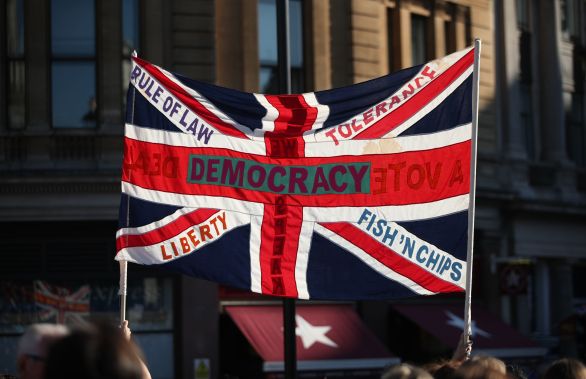 V októbri vyšli do ulíc Londýna státisíce ľudí, aby vyjadrili nesúhlas s brexitom. Foto - TASR/AP A British Union flag is held aloft bearing slogans including "Democracy", "Rule of Law", "Liberty", "Tolerance" and "Fish 'n' Chips", during the People's Vote March, in London, Saturday Oct. 20, 2018. Some thousands of protesters are marching through central London, Saturday, to demand a new referendum on Britainâs Brexit departure from the European Union. (Yui Mok/PA via AP)