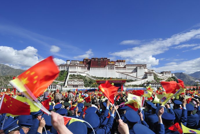 Tibetskí školáci mávajú čínskymi vlajočkami počas Pekingom riadených osláv. Foto - TASR