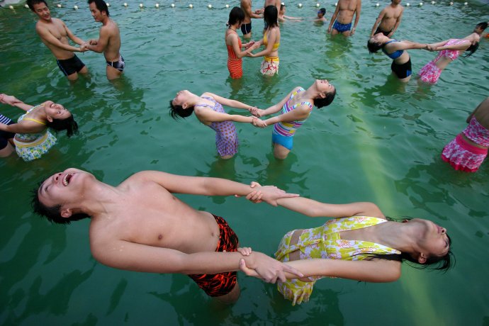 Inštruktorka predvádza jógové cvičenie v bazéne v západočínskom Čchong-čchingu. Stredná vrstva sa definuje aj tým, že má dosť času na zábavu. Ilustračné foto - tasr/ap