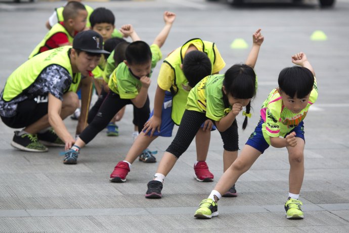Čínske deti sa učia techniku jazdy na kolieskových korčuliach v parku v Pekingu v júni 2015. Foto - tasr/ap