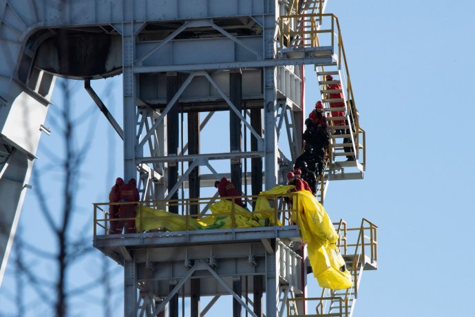 Policajti zakročujú proti aktivistom na ťažobnej veži v Novákoch. Foto – Greenpeace/Tomáš Halász