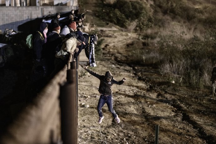 Migrant skáče cez hraničný plot na územie Spojených štátov. Foto - TASR/AP