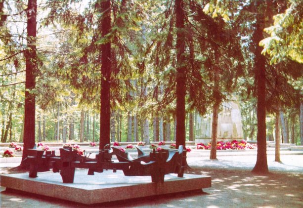 Plastika Utrpenie, v pozadí pamätník a cintorín. Foto z publikácie 40 slobodných rokov Trenčína, vydal MsNV, MKS a Dom ČSSP v Trenčíne, 1985.