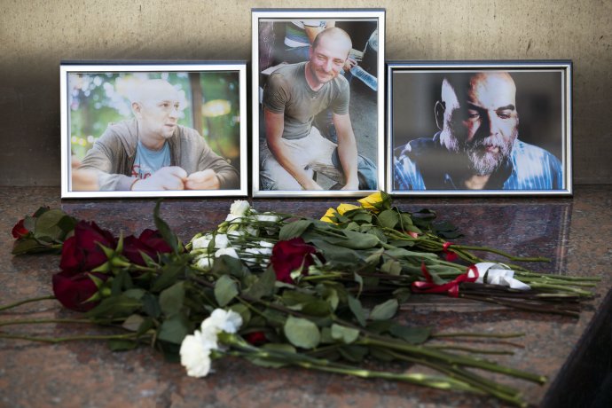 Kvety pred portrétmi zavraždených novinárov Alexanderom Rastorgujevom, Kirillom Radčenkom a Orchanom Džemaľom 1. augusta 2018 v Moskve. Foto - TASR/AP