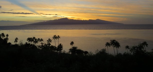 Východ slnka nad Tahiti z ostrova Moorea.