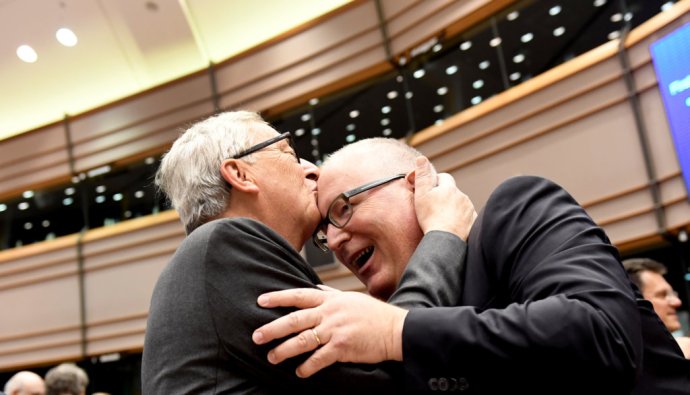 Predseda Európskej komisie Jean-Claude Juncker bozkáva na čelo prvého podpredsedu EK Fransa Timmermansa, ktorý vyhral holandské voľby a je kandidátom eurosocialistov na šéfa Komisie. Foto - TASR/AP