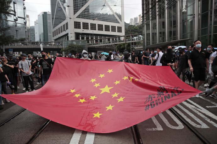 Demonštranti držia čínsku vlajku s hviezdami umiestnenými do tvaru svastiky. Foto – TASR/AP