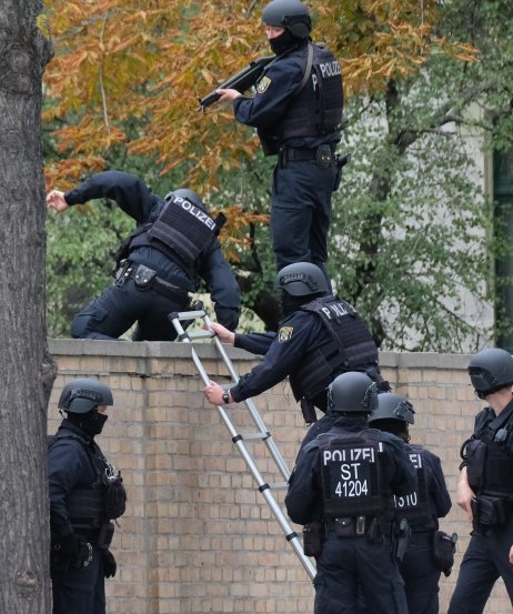Policajti preskakujú múr po streľbe v blízkosti synagógy vo východonemeckom meste Halle. Foto – TASR/AP
