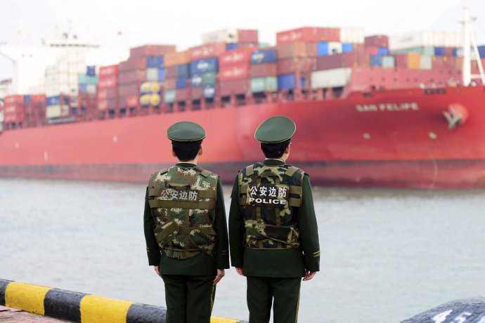 Čínski policajti sledujú kontajnerovú loď naloženú tovarom. Foto - TASR/AP