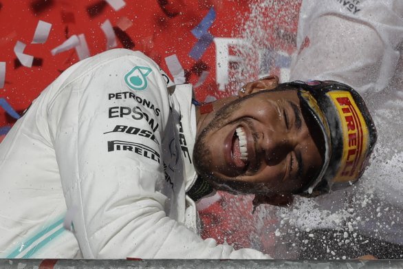 Lewis Hamilton oslavuje titul. Foto - AP Photo/Darron Cummings