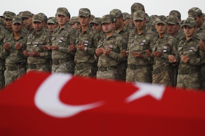 Tureckí vojaci nad rakvou mŕtveho vojaka, ktorý zahynul v bojoch proti Kurdom počas invázie do Sýrie. Foto - TASR/AP