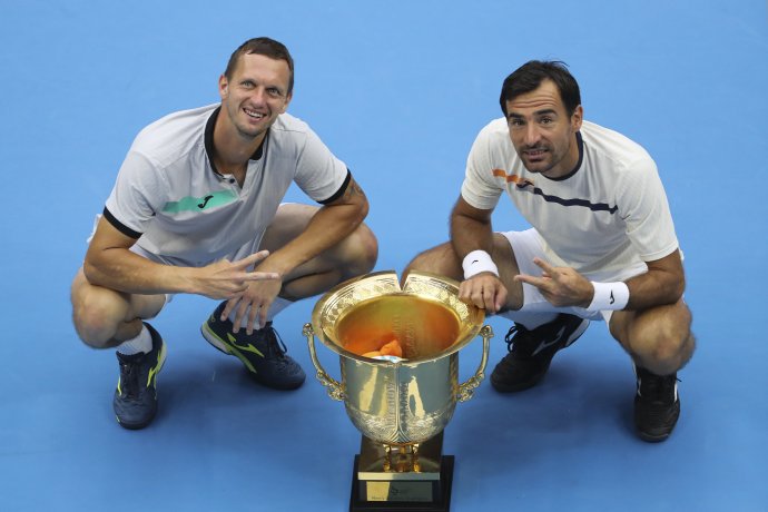 Filip Polášek (vľavo) a Ivan Dodig pózujú s trofejou po zisku titulu na turnaji ATP v Pekingu. Foto - TASR/AP